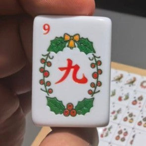 Close-up of the Christmas American Mahjong nine Crak tile decorated with a green holly wreath and red berries