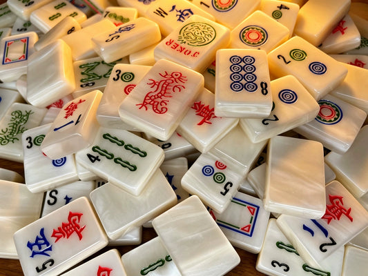 Classic Pearl American Mahjong tiles with luminous ivory mother-of-pearl finish and traditional red, green, blue and black markings.