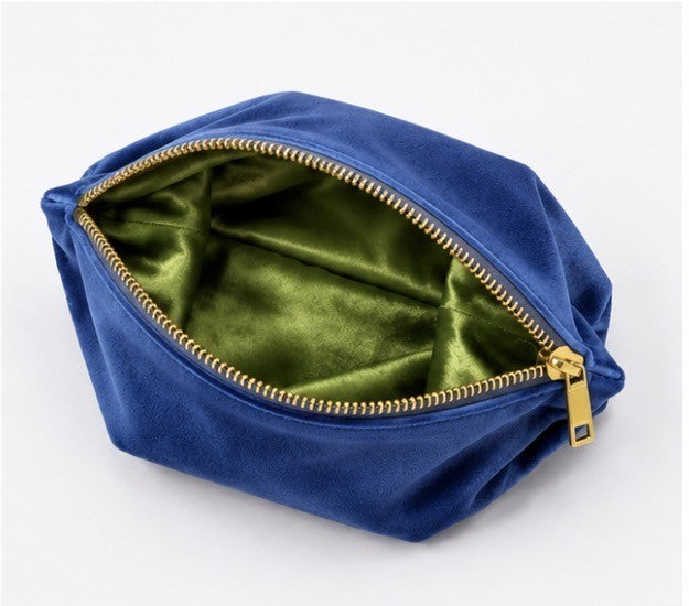 Blue velvet mahjong tile storage bag with green satin lining and zipper closure